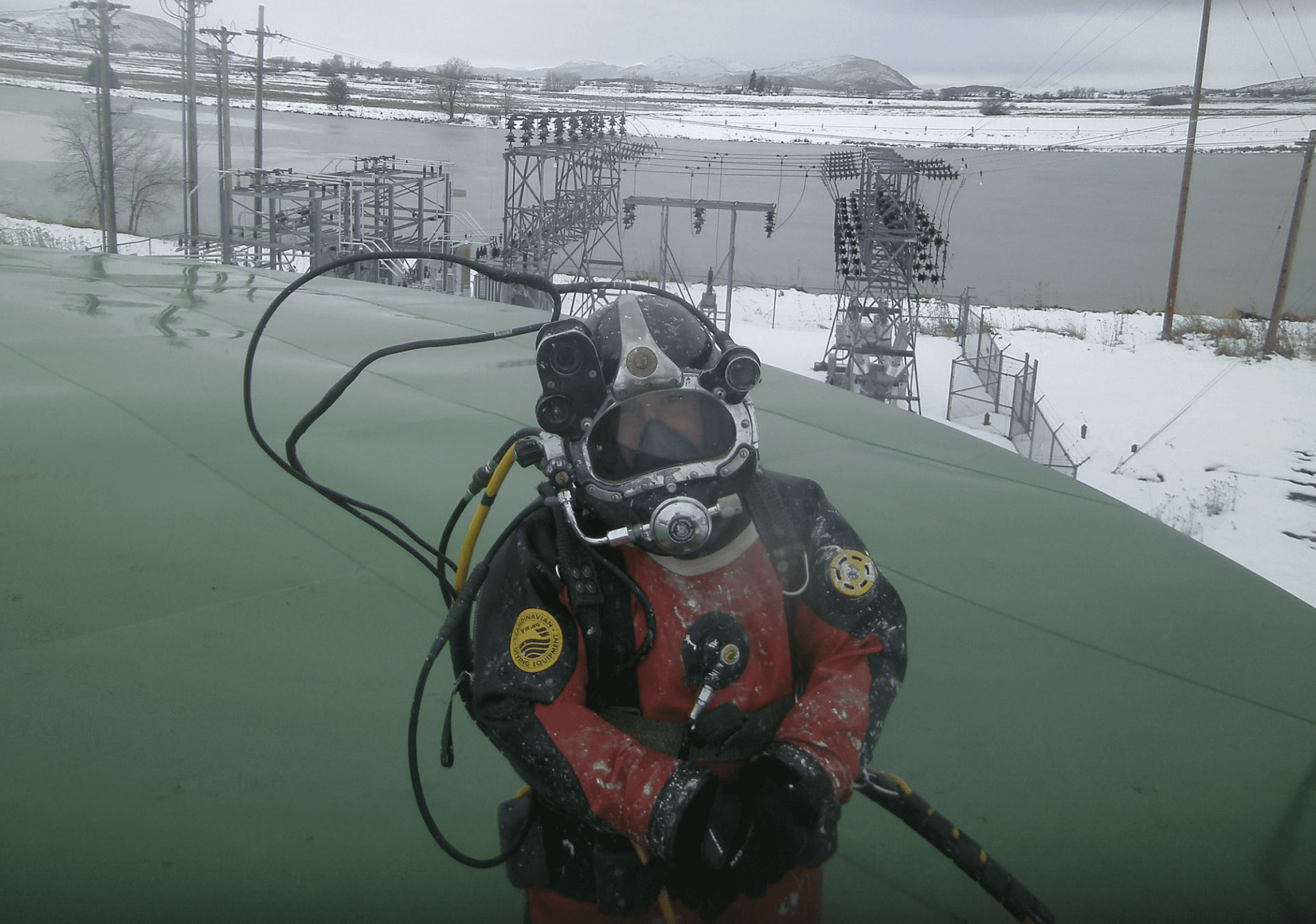 A diver entering a water reservoir in winter.